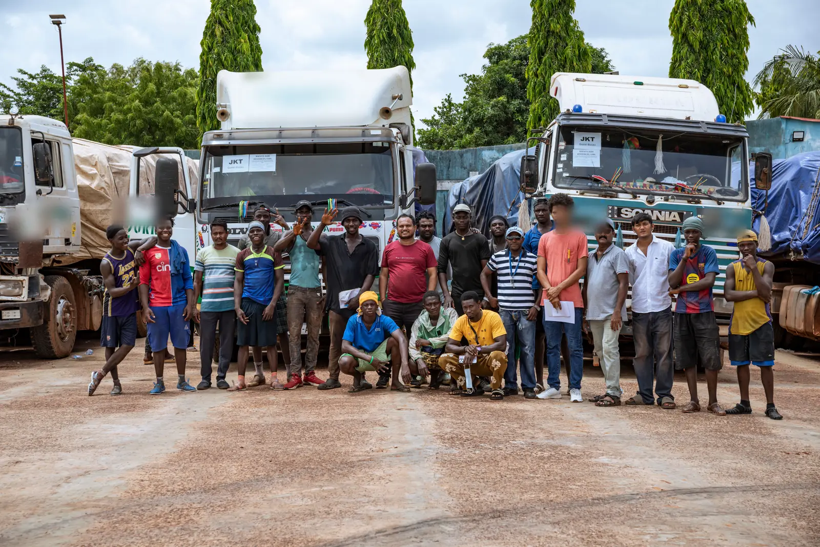 The Bafata Agri Resources team gathered in front of the loaded trucks, with the company's own consignment placards in the windscreens.